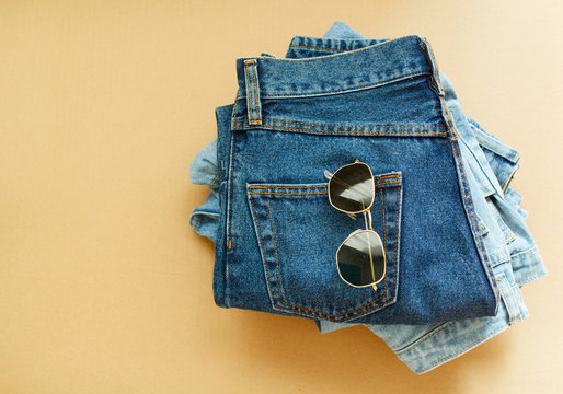 Picture of jeans with glasses on craft wooden background