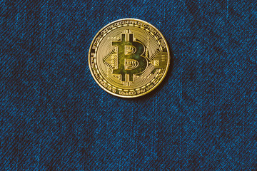 Golden bitcoins in the pocket of old vintage indigo stonewashed jeans. Concept of bitcoin - a...