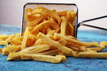 Tasty french fries on blue table background