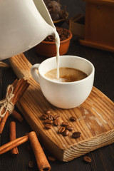 Morning coffee cup and spices on vintage wooden board