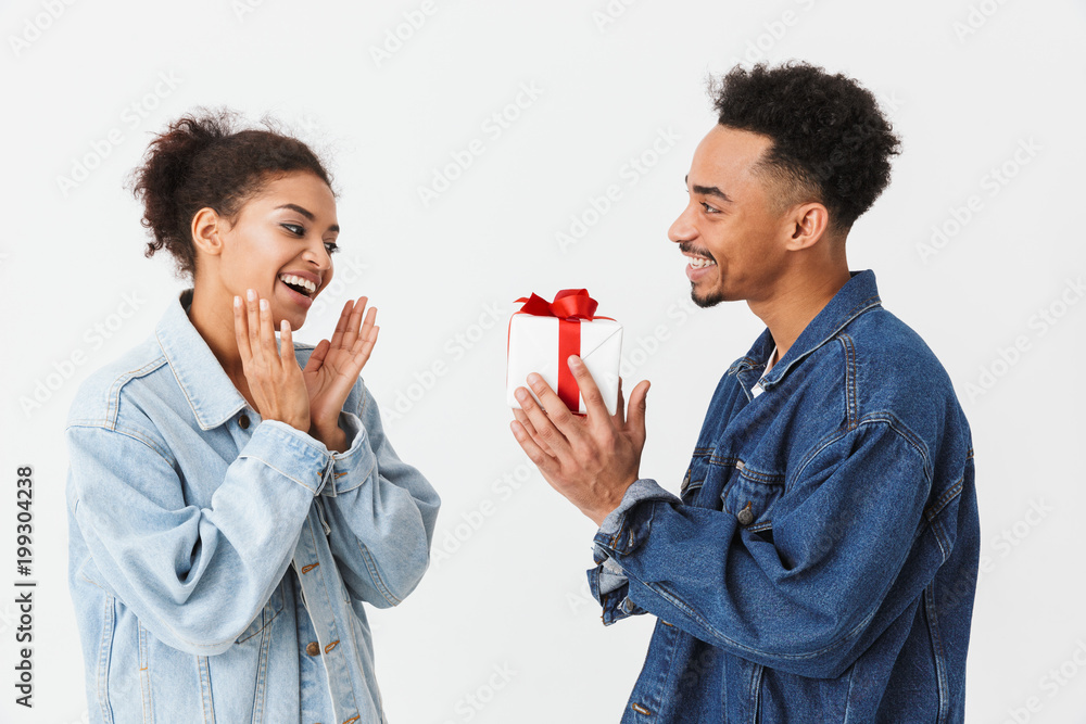 Wall mural side view of smiling african man giving gift box