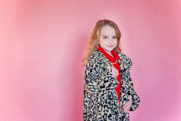 Little cute sweet smiling girl in red dress standing on pink colourful pastel trendy modern fashion pin-up background