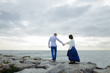 A loving couple, man and woman enjoying summer vacation on a tropical paradise beach with clear sea ocean water and scenic