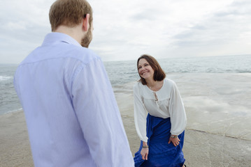 A loving couple, man and woman enjoying summer vacation on a tropical paradise beach with clear sea ocean water and scenic