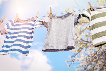 Baby clothes hanging on rope, isolated on white