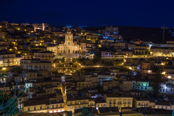 Fototapeta na wymiar Night view of the illuminated Modica and the imposing San Giorgio cathedral