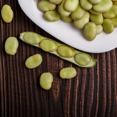 fresh broad beans on a rustic background