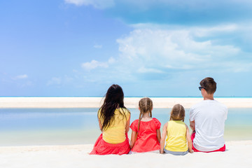 Obraz premium Parents and kids on beach vacation. Back view of family