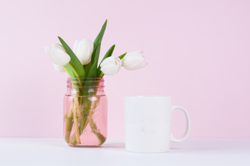 blank white mug mockup with white tulips against a pink background