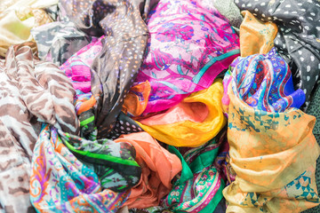 Background with scarves of different colors. Closeup, selective focus.