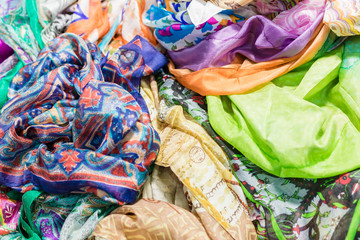 Background with scarves of different colors. Closeup, selective focus.