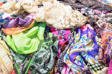 Background with scarves of different colors. Closeup, selective focus.