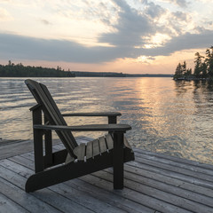 Fototapeta na wymiar Adirondack chair on a dock, Kenora, Lake of The Woods, Ontario, Canada