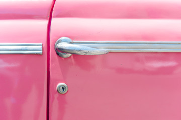 Closeup of classic pink vintage car in Old Havana, Cuba. The most popular transportation for tourists are used as taxis.