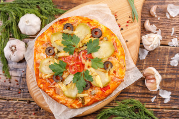 Delicious, fresh homemade pizza set on paper at wooden table.