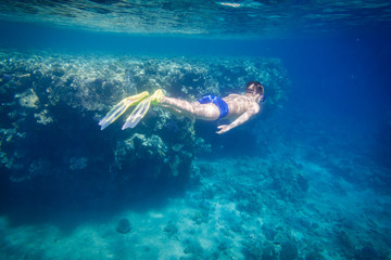 Plongée de garçon en mer rouge près de récif de corail