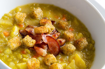 traditional pea soup decorated with croutons and bacon
