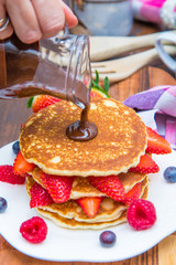 dish with pancakes and strawberry,raspberry and blueberry and chocolate 