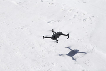 Drone Hovering over the snow taking pictures of white winter nature in the mountains