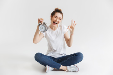 Portrait of a happy young girl holding alarm clock