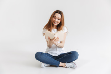 Portrait of a smiling young girl reading book