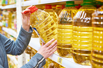 Big bottle of olive oil in hand buyer at grocery