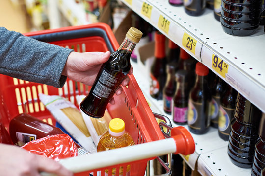 Soy sauce bottle in hand buyer at grocery store