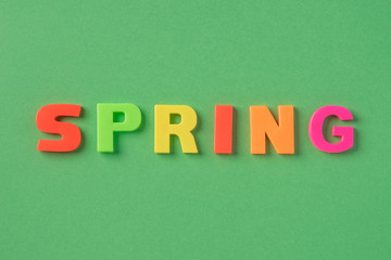 The spring inscription with plastic letters on a green background