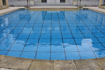 Piscine avec fond bleu à petits carreaux.