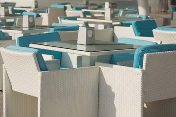 a street cafe in the early morning without visitors, a summer playground on the waterfront, tables and chairs