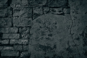 Halloween background of black old brick wall with fallen off plaster