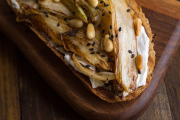 Fototapeta na wymiar Roast Organic Chicory on Bread Slice with Pine Nuts and Black Sesame. Organic Healthy Food.
