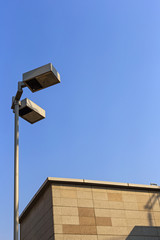 Part of the top of the building and lamp pole in the city.