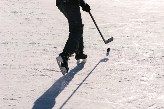 men play hockey on the rink during the day
