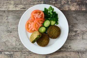 Grilled veggie hamburger with spinach and peas on wooden table. Top view