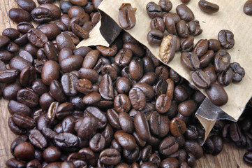 coffee beans in a bag and a part of wooden mill