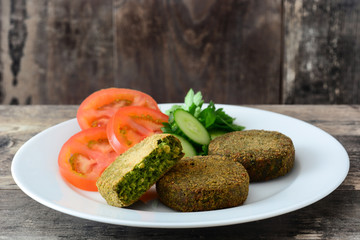 Grilled veggie hamburger with spinach and peas on wooden table