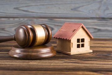Obraz premium mock house, hammer of a judge on a wooden background. property right.