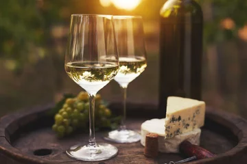 Crédence de cuisine en verre imprimé Vin Deux verres de vin blanc sur le vieux tonneau en bois à l& 39 extérieur. Coucher de soleil dans le vignoble.