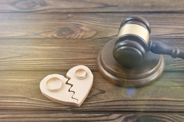 wedding rings, heart, judge hammer on a wooden background. family law