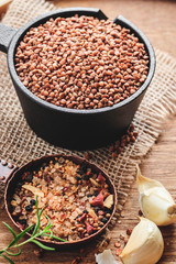 Buckwheat with spices on natural wooden background