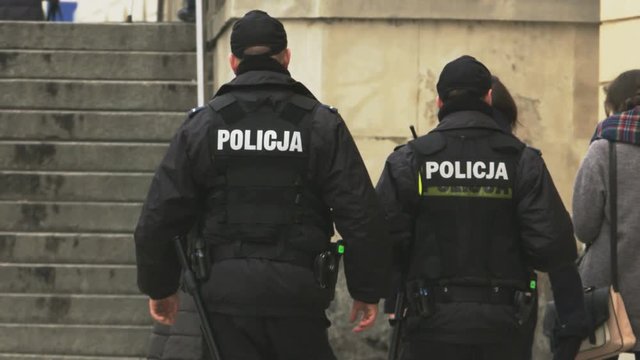 Two Policemen Walking Among Pedestrians