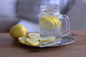 Glas of lemon juice on a old wooden table. Healthy detox drink with lemon.Blurred background.Food concept. Styled stock image.