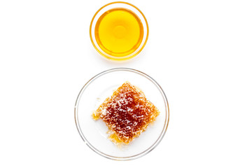 Honeycomb filled with honey on plate on white background top view space for text