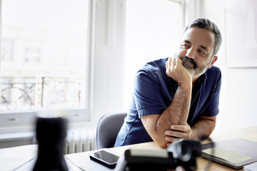 Thoughtful businessman sitting at desk in office