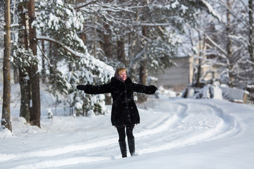 Young woman at winter in the snowy russian village.