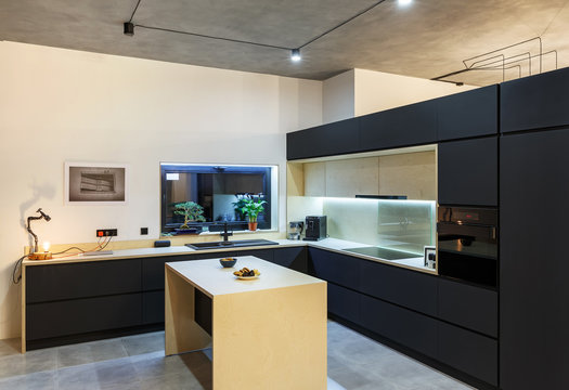 interior of a spacious kitchen with black facades in the loft style