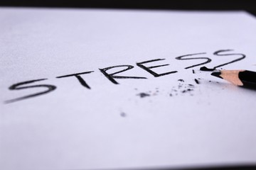 Stress Concept. Word stress written on white paper with broken pencil.