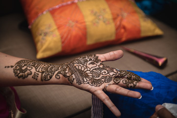 Fresh bridal henna tattoo. Bridal Indian henna design on woman's hand.