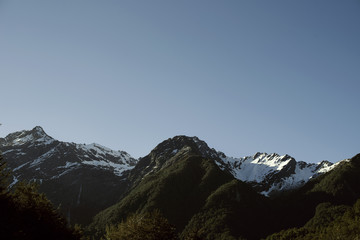 Fototapeta premium Paisaje de picos de montañas nevadas con cielo azul despejado en Nueva Zelanda